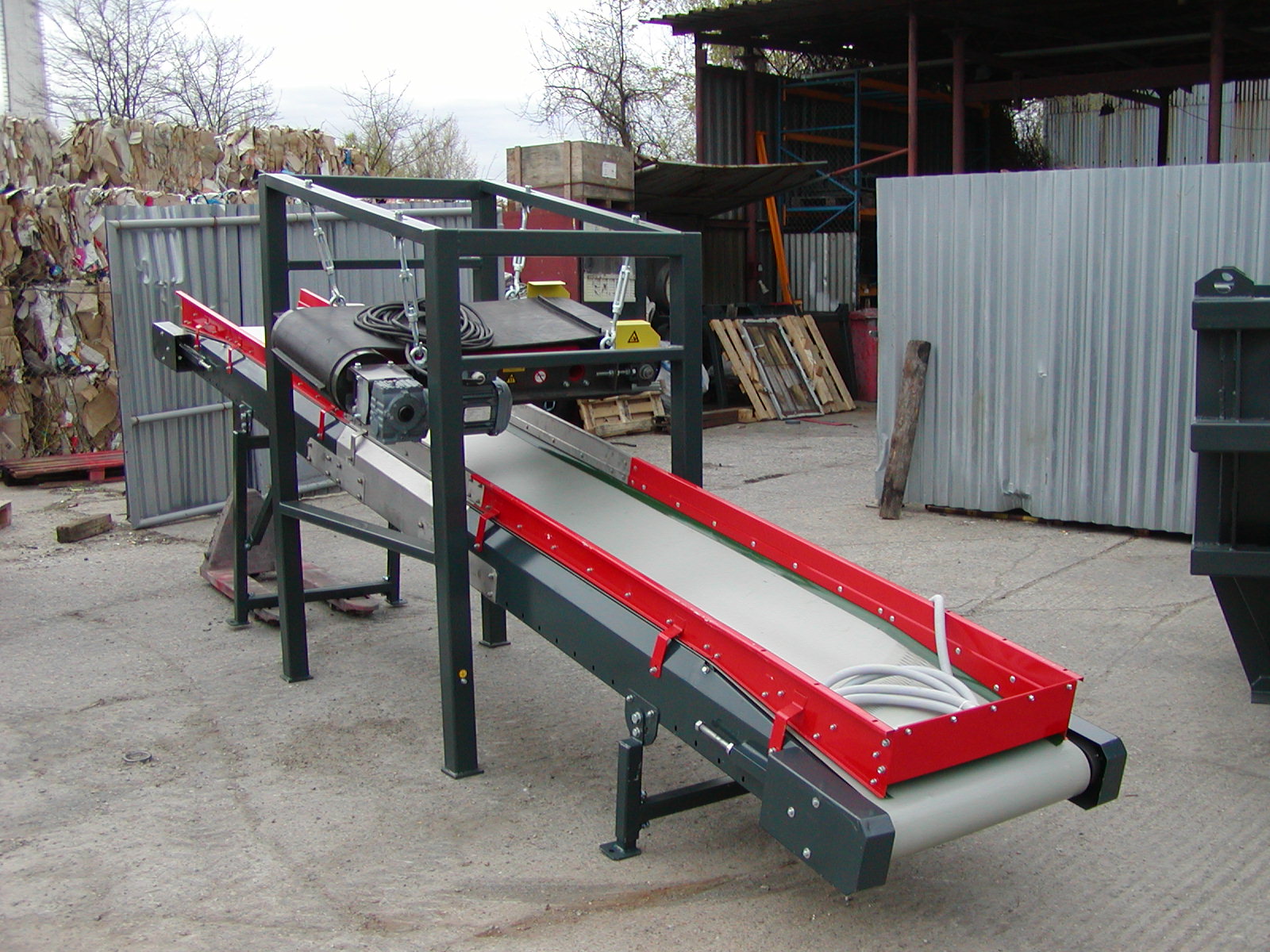 Conveyor for transporting shredded pallets, equipped with a magnetic separator